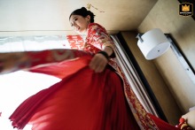 Bride in traditional red qipao at home in Shanghai, China, radiates joy and elegance from a unique creative shooting angle.