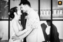 Escatalens: A married couple kisses in front of an old business establishment.