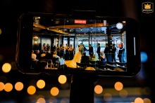 At District Winery, Washington DC, a detail shot captures a phone camera in video mode, recording the first kiss.