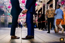 In City Center, Washington DC, a couple stands face-to-face, holding hands, captured from the shoulders down.