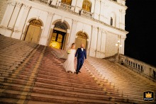 Bride and groom joyfully descend the grand stairs of Basílica Nossa Senhora das Dores in Porto Alegre, radiating happiness.
