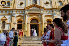 Bride and groom exit Paróquia Nossa Senhora da Glória in Porto Alegre as excited guests eagerly wait to celebrate outside.