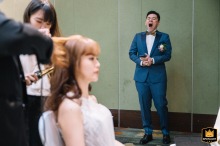 Hilton Taipei Sinban: Morning Wedding Preparations At Hilton Taipei Sinban, a soft-focus bride gets her hair curled in the foreground, while a tired groom yawns in the background.