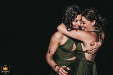 Two bridesmaids joyfully hug on the dancefloor at Grub, Manchester, celebrating a wedding with smiles and laughter.