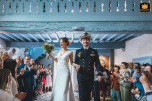 The bride and groom enter the deconsecrated chapel of Borce for their ceremony. Their guests cheer, creating a joyful and memorable atmosphere for their wedding in France.