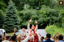 In Barrington Hills, IL, the groom arrives at the wedding ceremony during the vibrant baraat procession. Surrounded by lively music, dancing, and celebration, his entrance marks a joyful and colorful start to the festivities.