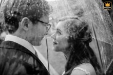 A black-and-white image of a bride and groom during a rainy wedding day at Haley Mansion. The intimate portrait captures the couple together, despite the weather, in a heartfelt pose.