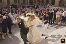 Wedding guests in Brisighella, Italy, toss rice at the bride and groom after their wedding ceremony.
