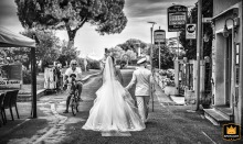 Black and white photo of a bride and groom walking away from the camera in the Italian town of Bocca di Magra.