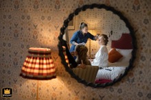 Reflection of a bride at Barnsdale Lodge Hotel, with her makeup done, on a floral wallpapered wall.