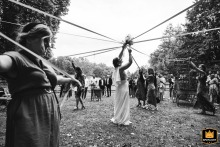 A documentary photograph captures a moment during a cocktail hour at Le Poudrier in Limoges, France. The image shows a ribbon game taking place at the charming riverside estate.
