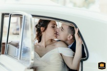Newlyweds share a kiss inside a vintage car after their San Pietro in Campiano church wedding.