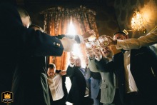 Groom toasting with friends in a hotel bar in Poland. A joyful wedding celebration moment captured.