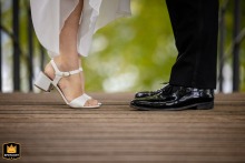 Bride and groom on a wooden deck at Seeleger Moor Park, bride lifting on her toes.