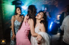 La Castella venue, Italy, is the scene where a bride and her best friend joyfully dance together, celebrating late into the lively wedding reception party.