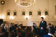 Poland, inside a historic church, is where the waiting groom stands solemnly at the altar, anticipating the arrival of his bride for their wedding ceremony.