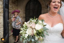 Bride laughing as her grandmother applies lipstick behind her at St Mary’s Church in Burton Latimer.