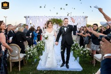 Bride and groom exiting outdoors in Perez, Santa Fe, as petals are tossed in the air over them, symbolizing love and celebration.