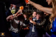 Party scene at Punta Barranca in Rosario, Santa Fe, with hands holding toasting drinks in the foreground.