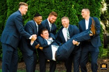 In Philadelphia, Pennsylvania, the groomsmen share a joyful moment together, lifting the laughing groom in celebration.