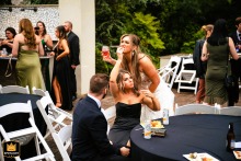 In Claymont, Delaware, a friend quickly delivers an item to the bride with perfect timing, responding to her subtle, nonverbal signal for food.