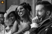At Fawsley Hall, Northamptonshire, the bride and groom share an emotional reaction during the best man's heartfelt speech. Captured in black and white, their faces reveal genuine love, gratitude, and deep connection in the moment.