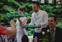 At their Budapest reception venue, the couple joyfully distributes playful, syringe-shaped party shots to their guests. Captured with a long lens, their laughter and the festive atmosphere stand out amidst the lively celebration.