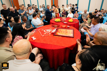 In a Taiyuan, Shanxi hotel, friends gather around round tables, slightly elevated in view, as they watch the bride eat dumplings, sharing warm smiles and enjoying the joyful wedding celebration together.