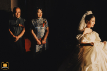In Kaifeng, Henan, the bride enters, walking past her parents. Her father and mother gaze at her intently, their eyes filled with love and pride as she proceeds down the aisle.