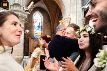At Eglise de Gouvieux, the bride and groom are warmly embraced by family and guests at the end of the ceremony, capturing genuine affection and support as the newlyweds are welcomed into joyous celebration.