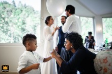 Guest Ties Balloon to Child While Bride and Groom Mingle at Terme Vallio At Terme di Vallio in Vallio Terme, a guest ties a balloon to a child’s wrist while, in the background, the bride and groom chat with other guests, highlighting a festive and interactive scene during the celebration.