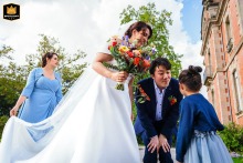   In Limoges, France, the couple pauses before the ceremony to chat with a child, while a witness helps adjust the wedding dress for the special moment ahead.