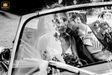   Inside a car in Bern, Switzerland, the groom leans in for a quiet kiss with his bride, offering them a private, intimate escape from the day’s celebrations.