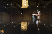 During their first dance at Windows on the River in Cleveland, OH, the couple shares an intimate embrace, softly illuminated by reflected lights in the romantic reception setting.