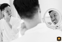 A candid moment captured during brushing time shows the detailed wedding preparations taking place at the lush and historic Nai Lert Park Heritage Home located in Bangkok, Thailand.