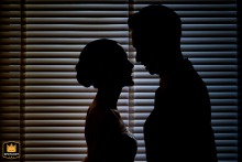 The bride and groom appear as a romantic silhouette couple while posing together at the historic Nai Lert Park Heritage Home in Bangkok during their beautiful evening celebration.