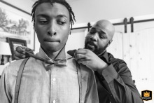 A groom kindly helps a member of his wedding party adjust a bow tie while preparing for the ceremony at Ott Farm and Winery in Blue Ridge, Georgia.