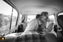 On a quiet road in Ille-et-Vilaine, Brittany, the newly married couple embraces for their first hug as husband and wife before arriving at the reception, sharing a private, affectionate moment away from the crowd.