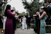The newlyweds walk back down the aisle following their outdoor ceremony in São Paulo, Brazil, as guests applaud and celebrate their joyful exit as husband and wife.