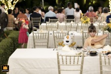 Guest Olaf sits beside a young girl at a reception dinner table at Baan Dusit Thani in Bangkok, Thailand, creating a charming and relaxed scene during the celebration.