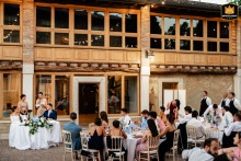 Bridesmaids Deliver Speeches During Dinner At Borgo La Caccia In Pozzolengo, Italy An overview of the wedding dinner setup at Borgo la Caccia in Pozzolengo (BS), Italy, shows guests gathered in the courtyard as the bridesmaids deliver their speeches.