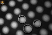 Wedding rings hang suspended against soft light and shadows in Bucharest, Romania, creating a minimalist composition that highlights commitment, connection, and enduring love.