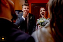 The godparents react with surprise and joy during the civil ceremony in Bucharest, Romania, creating an authentic and emotional scene as they witness a memorable wedding-day exchange.