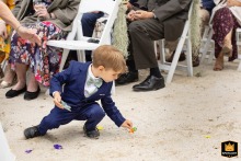 A young ring bearer picks up his dropped Ring Pop from the sand at Lake Mohawk Country Club in Sparta, New Jersey.