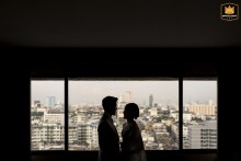 At Asia Hotel Bangkok, the silhouetted couple stands close together, their outlines softly lit to emphasize romance and movement within the reception space.