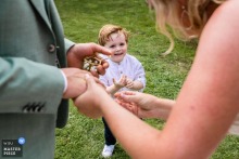 In Zuid Holland, Netherlands, a heartwarming scene unfolds during a wedding ceremony as a child presents a ring and demonstrates how to properly place it on a finger. A touching moment of love and unity.