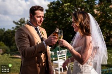 Newlyweds Share Joyful First Toast with Beer and Prosecco at Romantic Belpoggio Su Todi, Italy Wedding The groom, holding a beer, and the bride, holding prosecco, share their first toast as a married couple on a sunny day at Belpoggio Su Todi in Todi, Umbria, Italy.