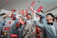 At HOTEL COZZI in Taipei, Taiwan, the groom and groomsmen playfully use chopsticks to catch floating paper bills during door games.