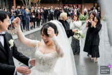 At BRICK YARD 33 1/3 in Taipei, Taiwan, the bride tosses her bouquet to enthusiastic single wedding guests.