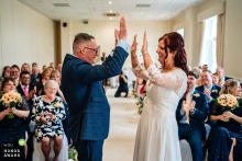   Moments after being announced husband and wife at Basingstoke Country Hotel, the bride and groom celebrate by enthusiastically sharing high fives.